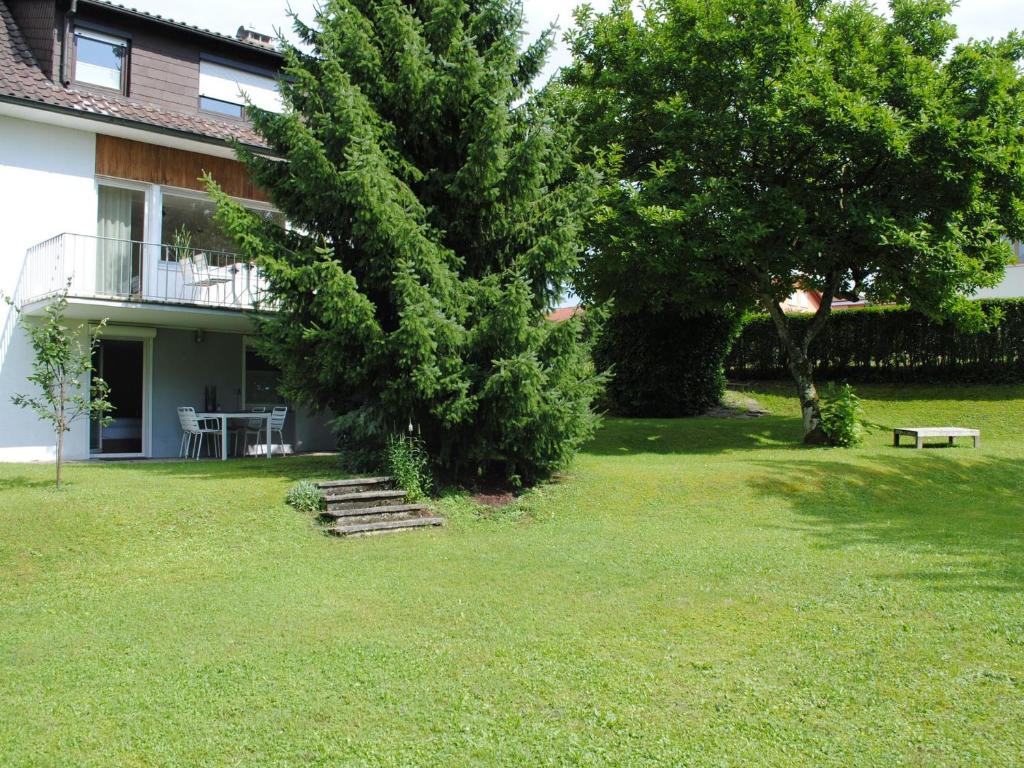 una casa con un árbol y escaleras en un patio en Ferienhaus Joos, en Uhldingen-Mühlhofen
