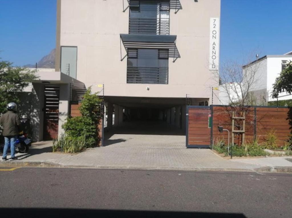 Cape Town的住宿－Unit 17 , 72 on Arnold street Two Bedroom Flat，一座带停车场的建筑,设有车库
