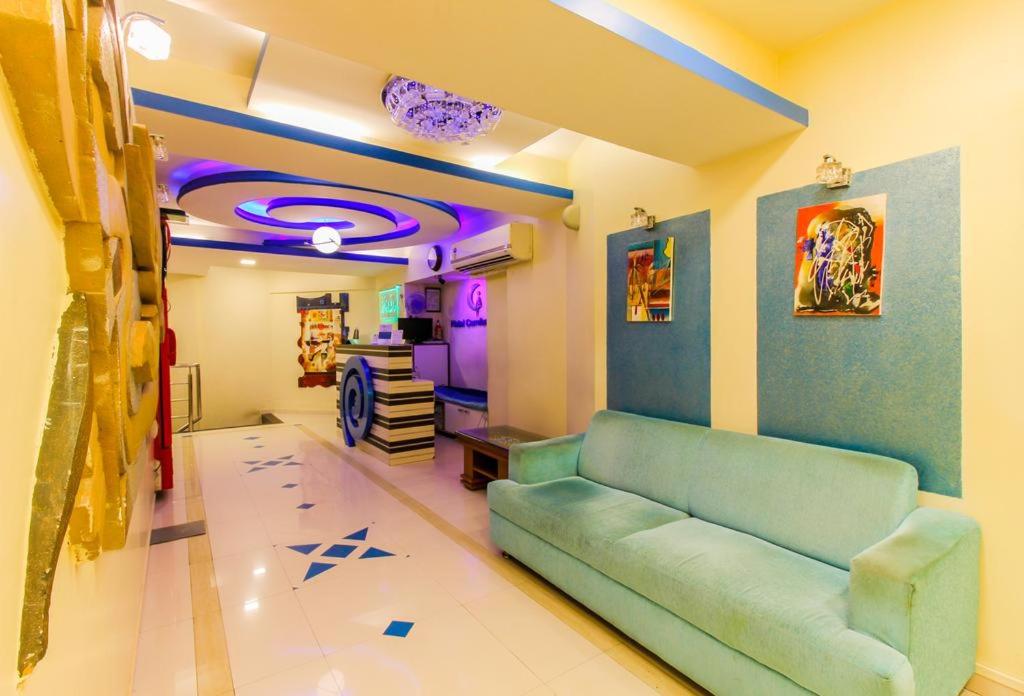 a living room with a blue couch in a room at Hotel Grand Corp Inn, Near Nesco Exhibition Center in Mumbai