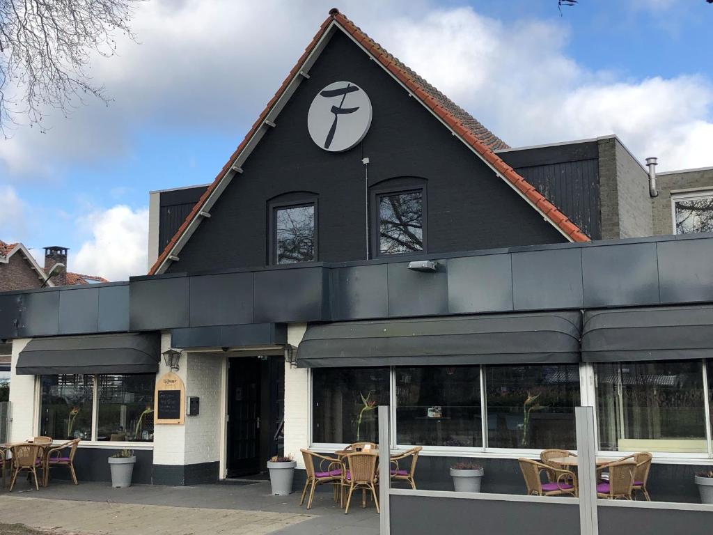 een zwart gebouw met tafels en stoelen ervoor bij Fletcher Hotel-Restaurant Waalwijk in Waalwijk