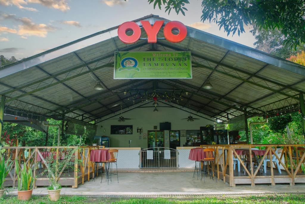 restauracja ze stołami, krzesłami i znakiem w obiekcie OYO 90037 The 7 Lodge Tambunan w mieście Tambunan