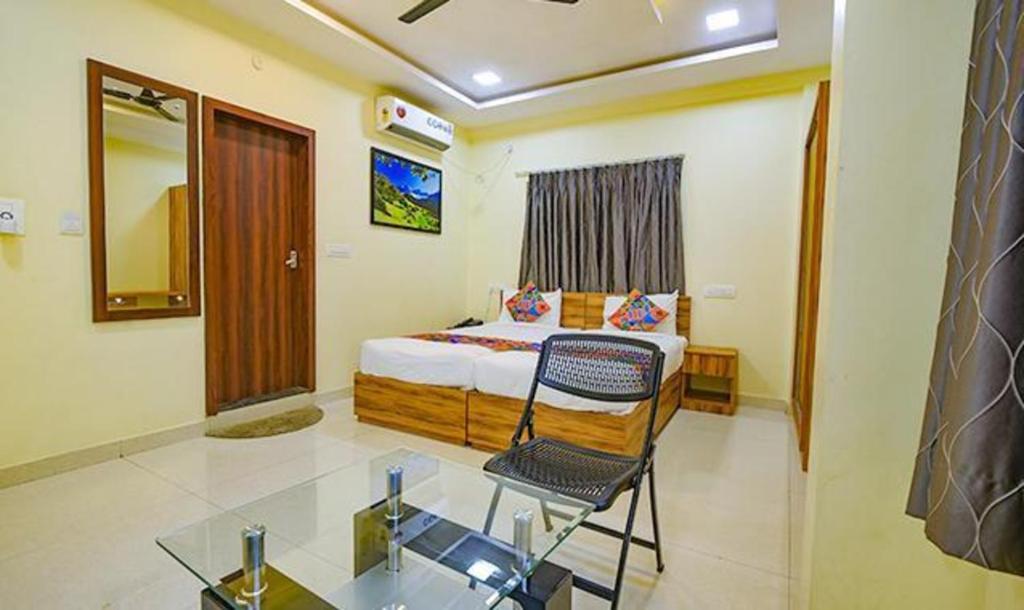 a bedroom with a bed and a glass table at FabExpress Purple Suites Inn in Bangalore