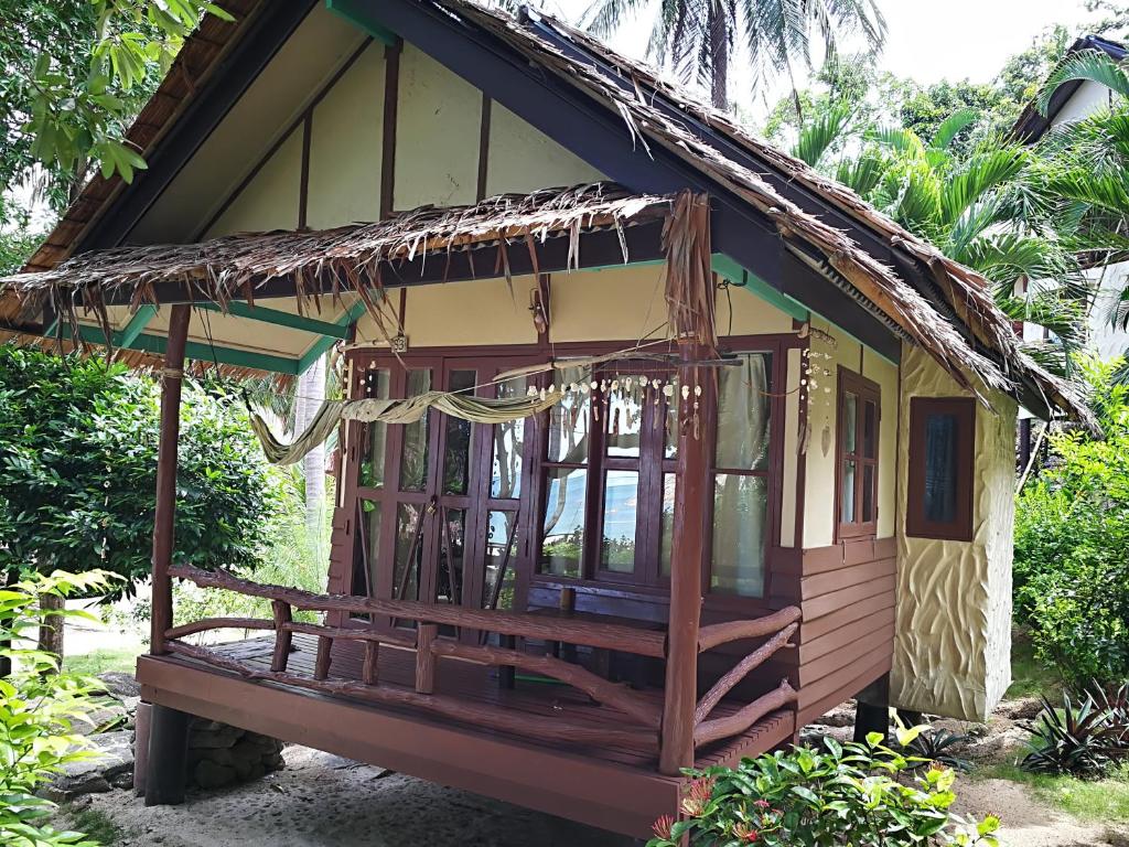 a small house with a thatched roof at Smile Bungalow Bottle Beach in Bottle Beach