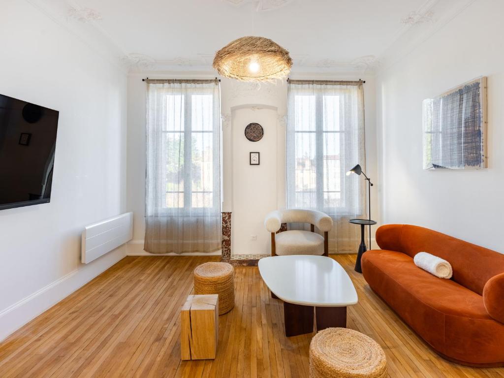 un salon avec un canapé et une table dans l'établissement Le Charmant de Medreville * Nancy, à Nancy