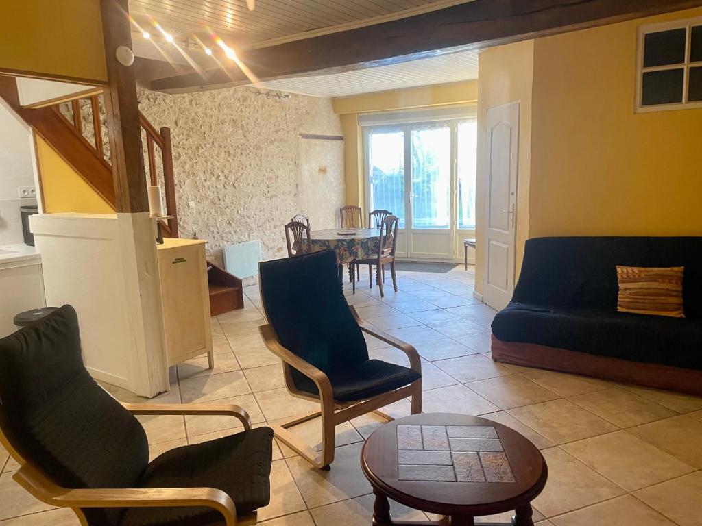un salon avec un canapé, des chaises et une table dans l'établissement Les Gites de La Vieille Roue - Gite 2, à Reignac