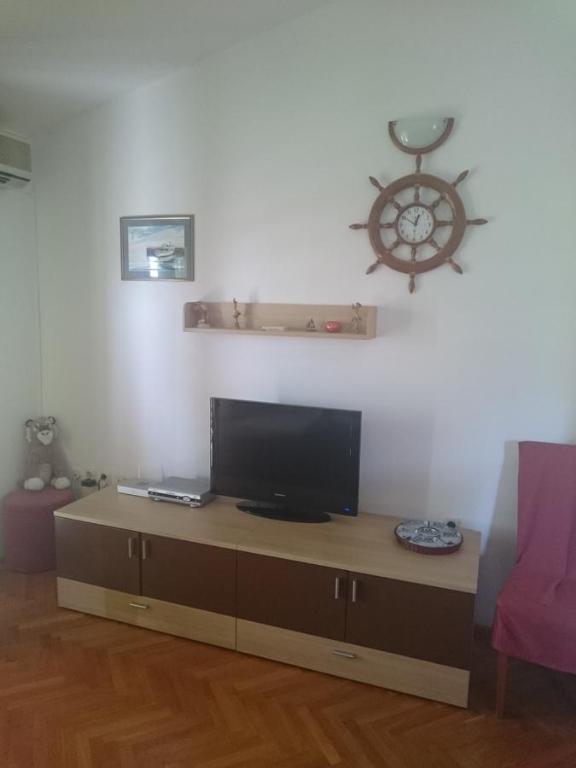 uma sala de estar com uma televisão de ecrã plano sobre uma mesa em Apartment More em Tučepi