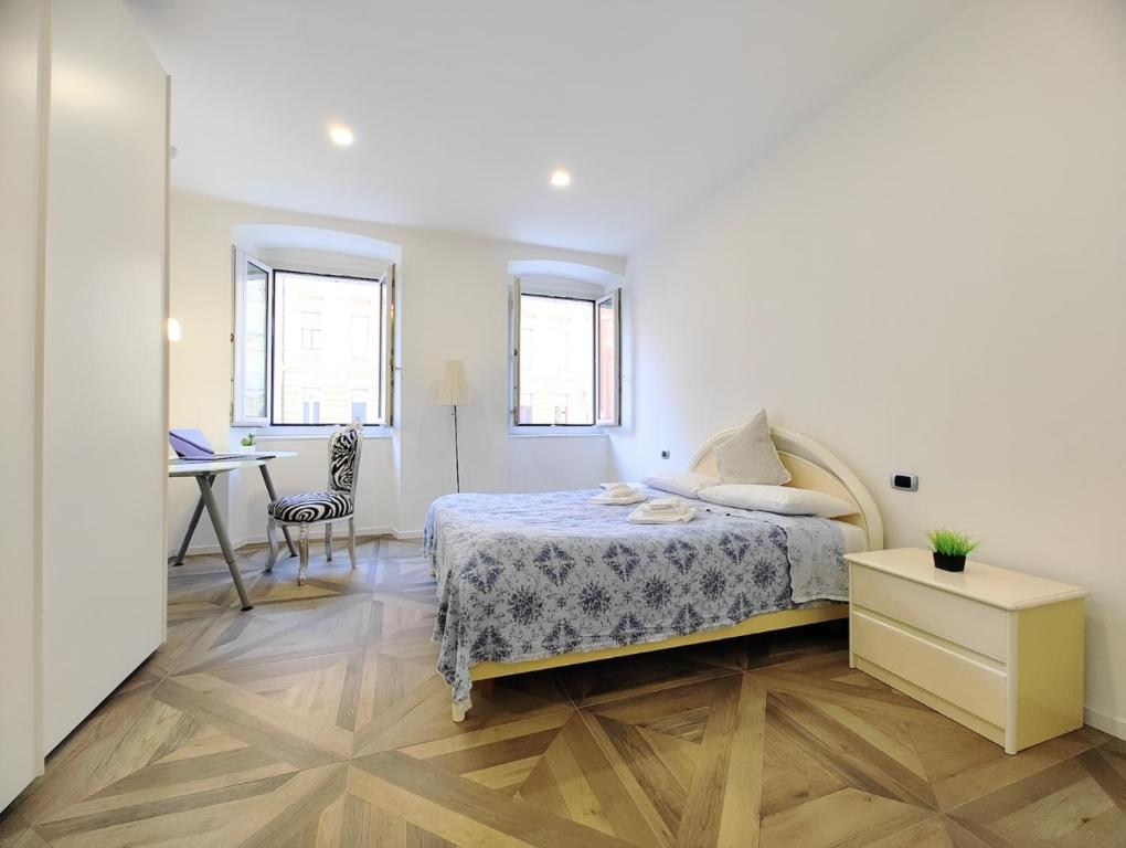 a bedroom with a bed and a desk in a room at Trieste Stazione - Suite & WiFi in Trieste