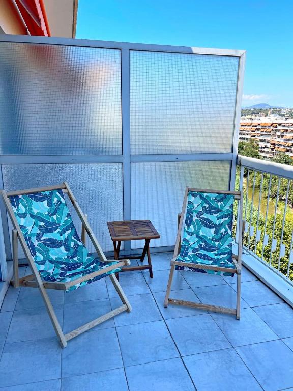 two chairs and a table on a balcony at Le Chaville in Cagnes-sur-Mer