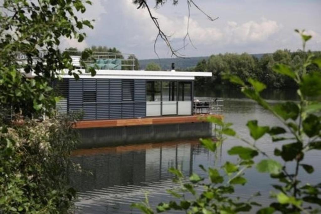 a house on a dock on a body of water at Hausboot freiZeit - LP1 in Höxter