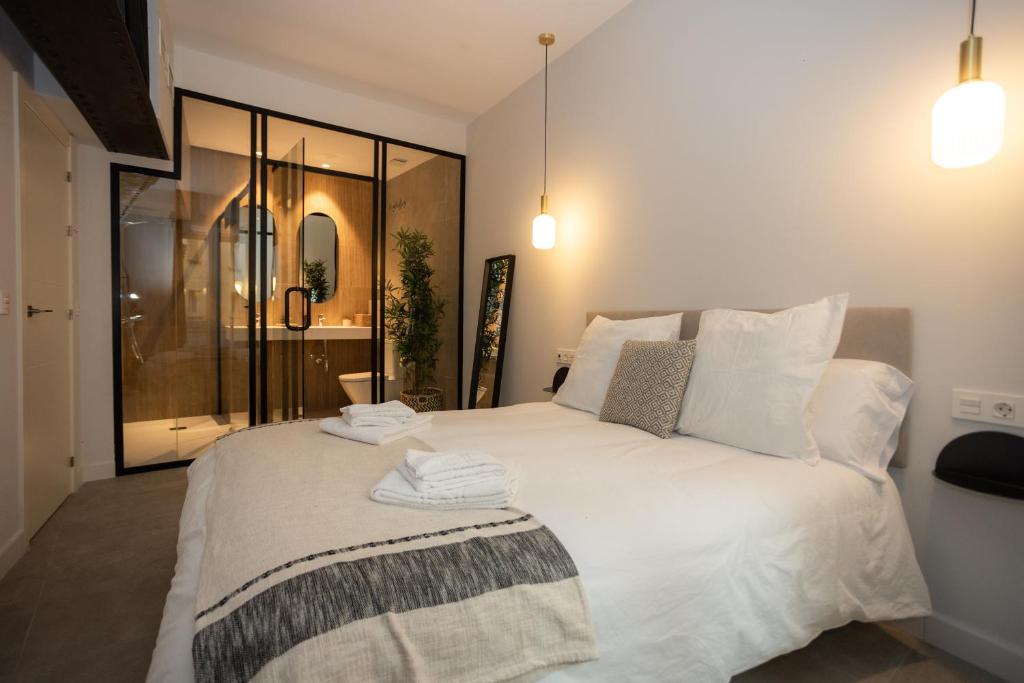 1 dormitorio con 1 cama blanca grande y toallas. en Diana Suites 23, en Málaga