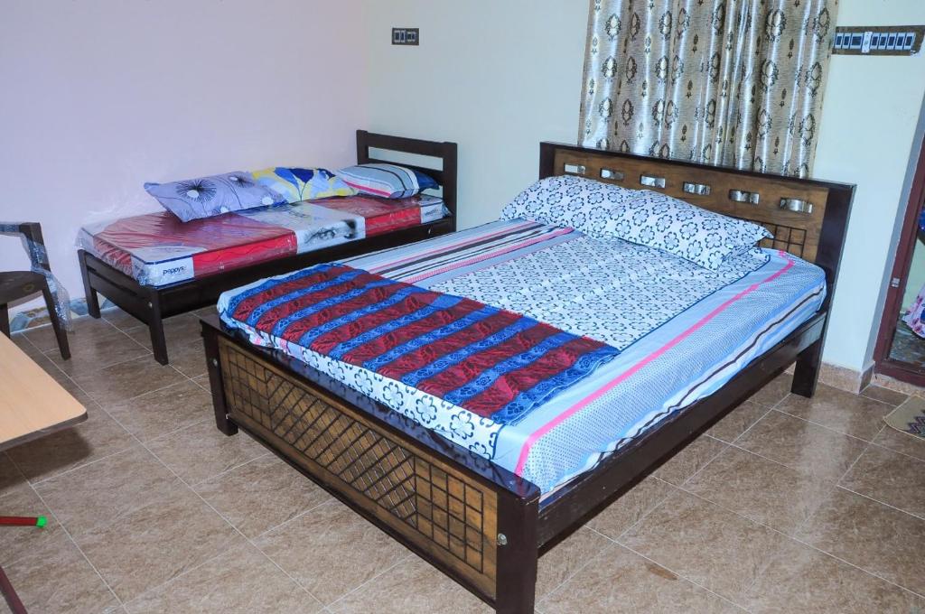 a bedroom with two beds and a table at GK RESIDENCY in Tiruvidaimarudūr