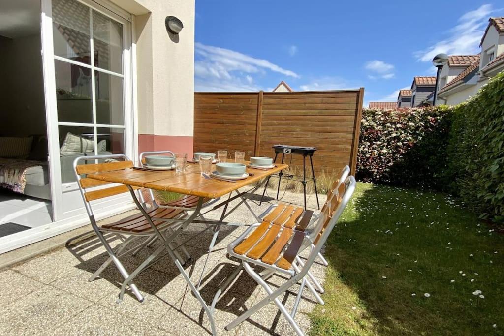 une table et des chaises assises sur une terrasse dans l'établissement Maison 4 personnes avec jardin et parking, au Crotoy