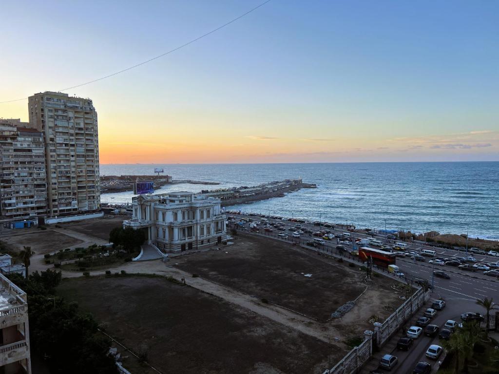 Sea View Luxury Apartment في الإسكندرية: اطلالة على المدينة والمحيط وقت الغروب
