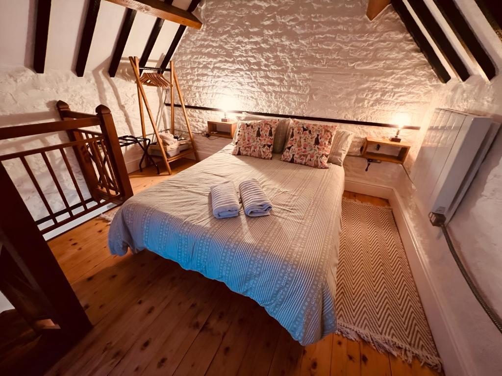 a bedroom with a bed with two towels on it at The Dog House, Mere in Mere