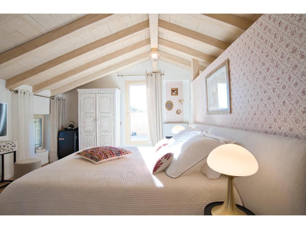 a bedroom with a large bed with white pillows at Le Mas des Aires - Chambres d&#39;Hôtes - Blauzac -Uzès - Pont du Gard in Blauzac