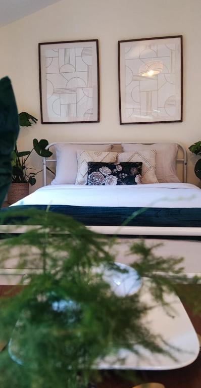 une chambre avec un lit avec deux tableaux au mur dans l'établissement La Green Room, à Poitiers