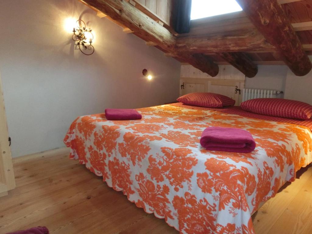 1 dormitorio con 1 cama grande con almohadas rojas en CORTINA LODGE, en Cortina dʼAmpezzo