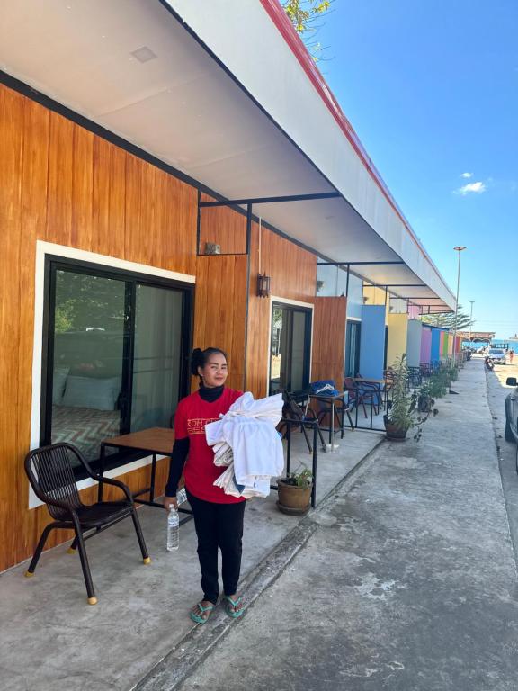a woman is standing outside of a building at Lonely beach complex titanic hotel in beach shopping street markets ในศูนการค้าติดทะเล in Khlaung Phai Bae