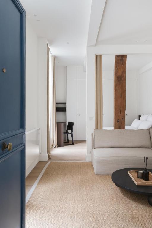 un salon avec un canapé et une table dans l'établissement Adresse Prestigieuse: Appartement Luxueux Marais, à Paris