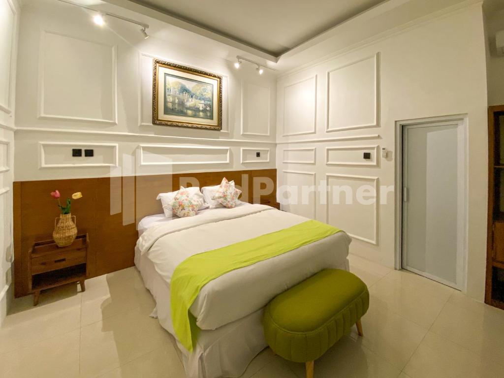 KadiporoにあるCBG INN RedPartner near Stasiun Solo Balapanのベッドルーム(ベッド1台、緑のオットマン付)