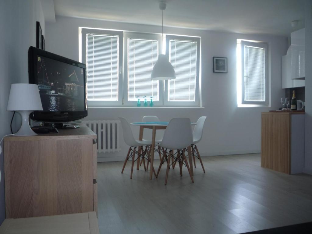 a living room with a tv and a table and chairs at Mieszkanie Przy Plaży in Gdańsk