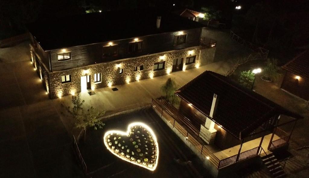 un bâtiment avec un cœur éclairé la nuit dans l'établissement EVIA FOREST VILLAGE, à Pappádhes