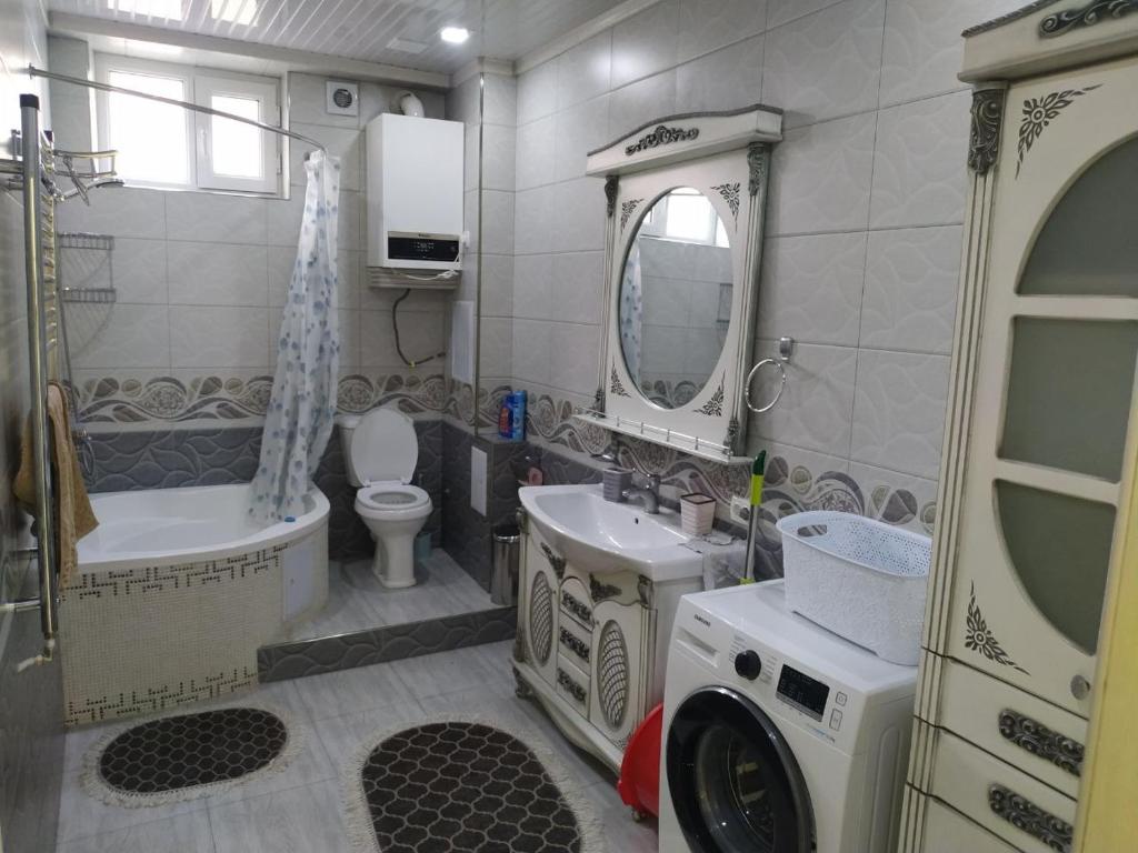 y baño con lavabo y lavadora. en Апартамент в центре города, en Andizhan