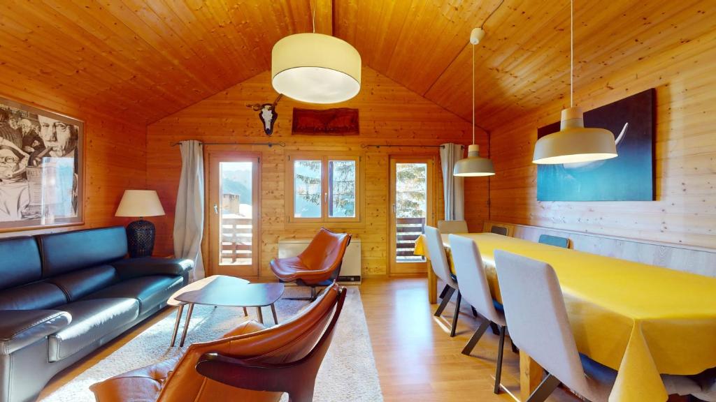 a living room with a couch and a table and chairs at Family chalet in the heart of the Val d'Anniviers in Saint-Luc