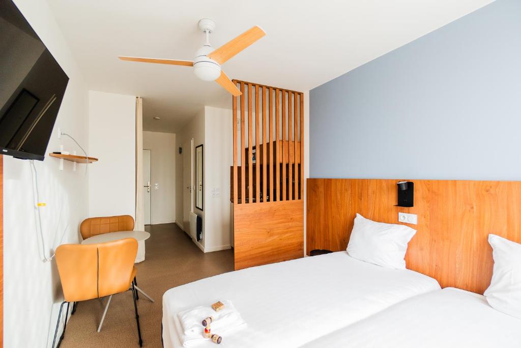 1 dormitorio con 1 cama, TV y silla en Ecla Paris Villejuif, en Villejuif