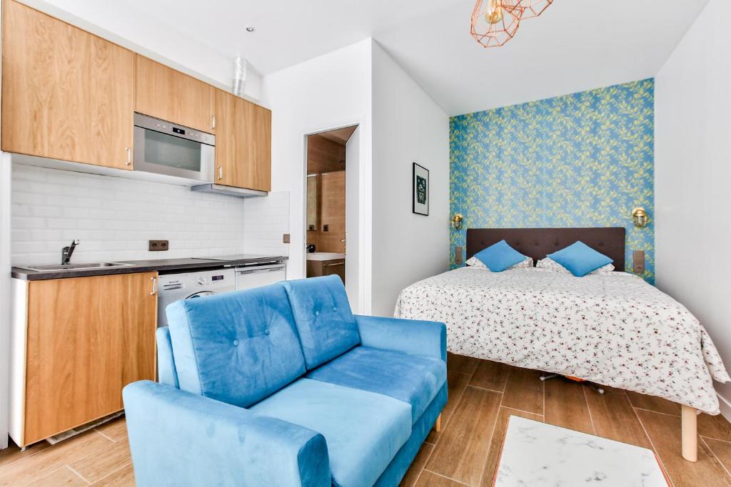 une chambre avec un lit et un canapé bleu dans l'établissement Suite Montorgueil, à Paris