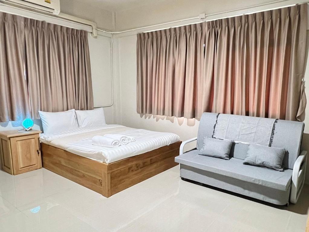 ein kleines Schlafzimmer mit einem Bett und einem Stuhl in der Unterkunft Muji Hotel KrabI in Krabi