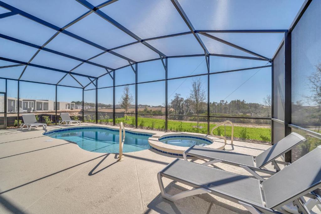 una piscina con una casa de cristal con patio en 7655 Oakmoss Loop, en Loughman