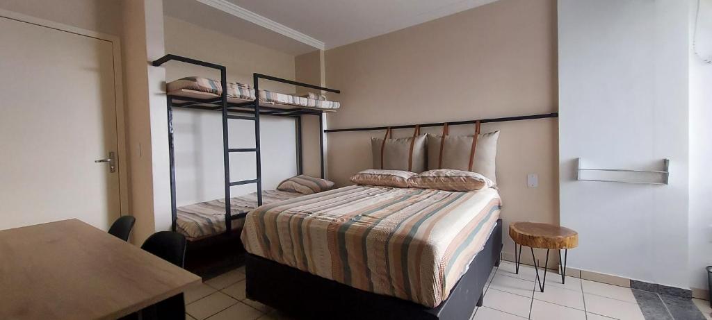 a bedroom with two bunk beds and a table at Suíte e copa com vista - Di Roma Rio Quente in Rio Quente