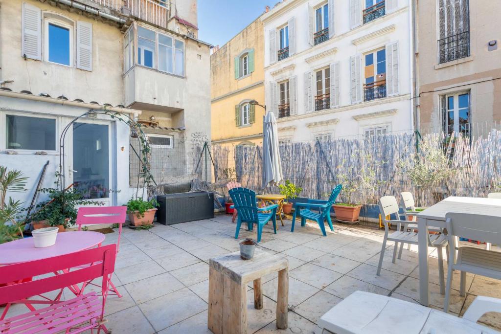 d'une terrasse avec des chaises, des tables et des bâtiments colorés. dans l'établissement Cozy 1 bedroom apartment in La Plaine district, à Marseille