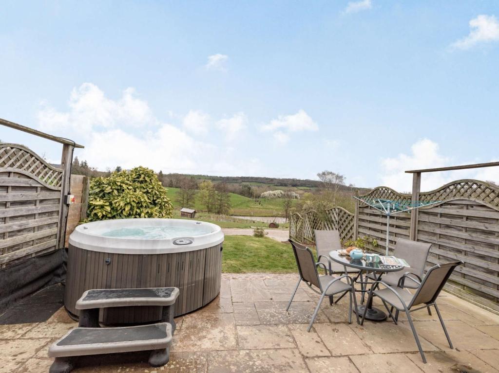 a hot tub on a patio with a table and chairs at 2 Bed in Worcester CC065 in Clifton upon Teme