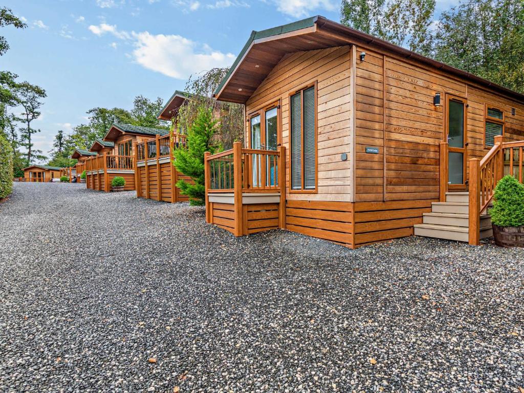 a row of wooden lodges on a gravel driveway at 1 Bed in Coniston Water 50081 in High Nibthwaite