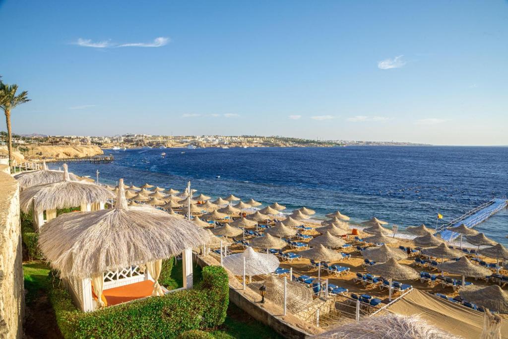 un montón de sombrillas en una playa con el océano en Sultan Gardens Resort, en Sharm El Sheikh