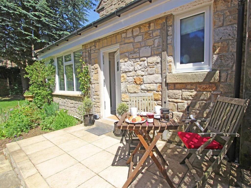 a patio with a table and chairs in front of a stone house at 1 Bed in Nr Hexham CN196 in Wall