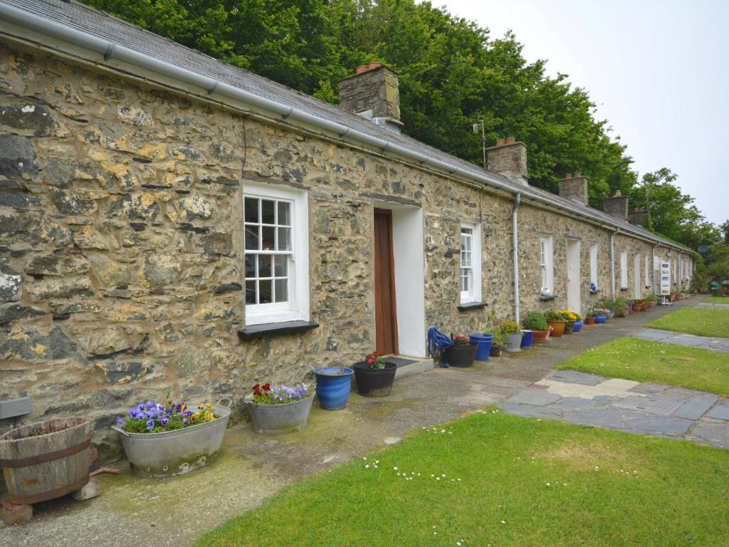 a row of stone houses with potted plants on them at 1 Bed in Porthgain 61170 in Porthgain
