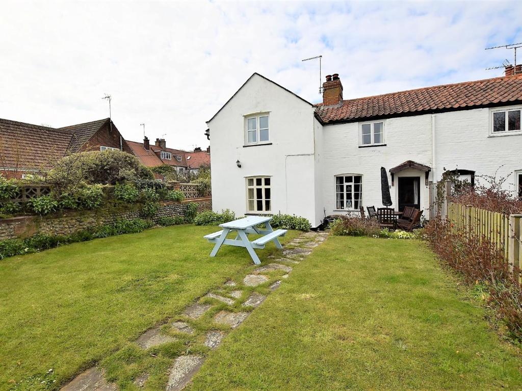 a white house with a picnic table in the yard at 3 bed property in Mundesley KT043 in Mundesley
