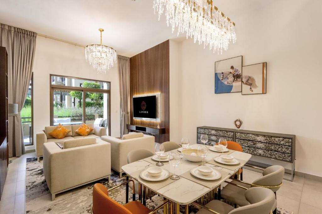 a dining room and living room with a table and chairs at Livbnb - 2BR close to Souk Mall and Burj Al Arab in Dubai