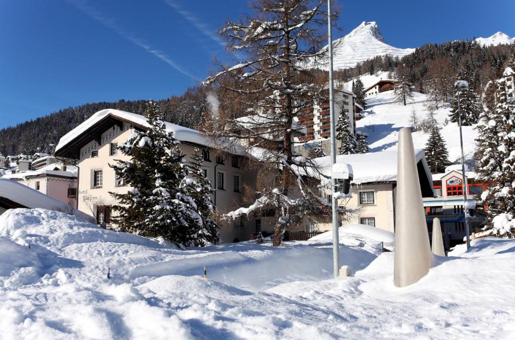 un bâtiment dans la neige devant une montagne dans l'établissement Hotel Parsenn, à Davos