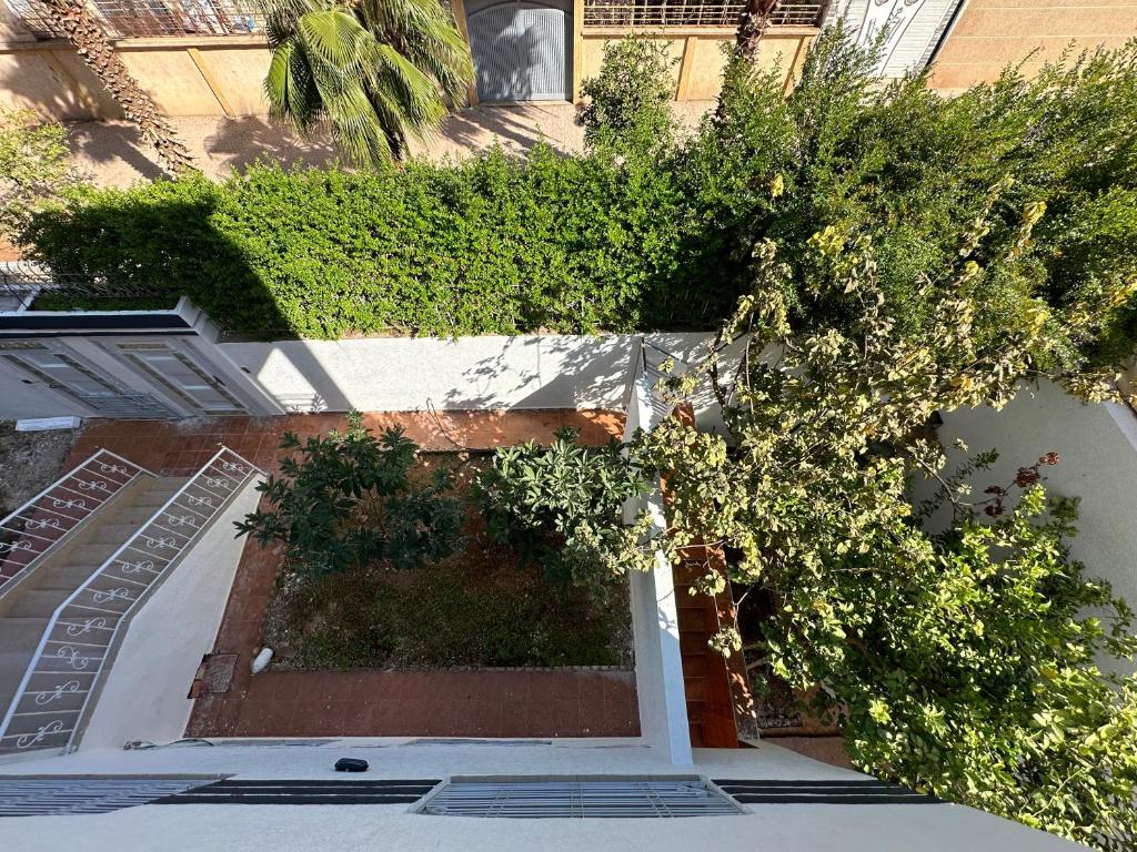 a building with a courtyard with trees and bushes at الطابق الأول لفيلا مجهز بامتياز in Fez