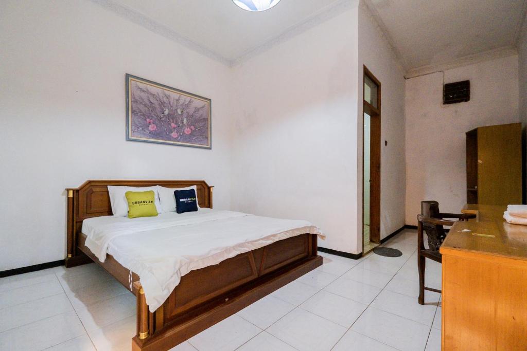 Tempat tidur dalam kamar di Urbanview Hotel Near Jatim Park 1 by RedDoorz