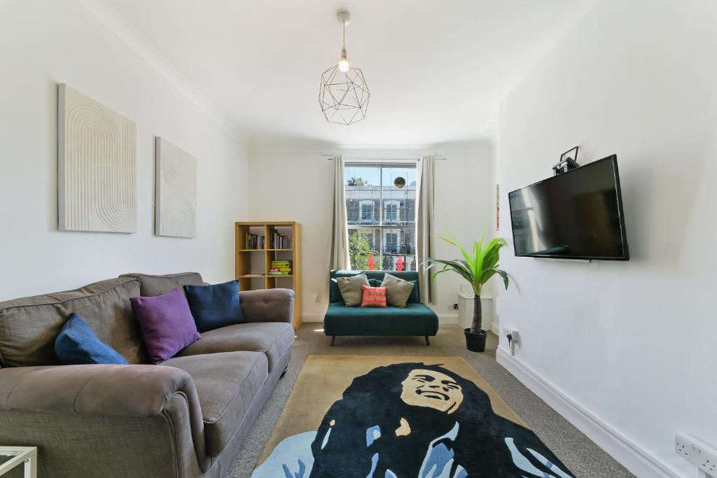 a living room with a couch and a flat screen tv at Spacious Maida Vale 2 Bed Apartment in London
