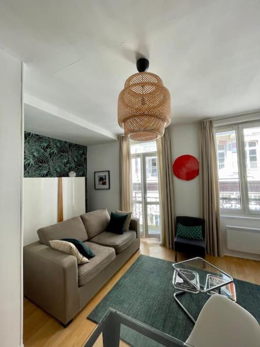 a living room with a couch and a table at Appartement à côté de la plage avec balcon filant in Trouville-sur-Mer