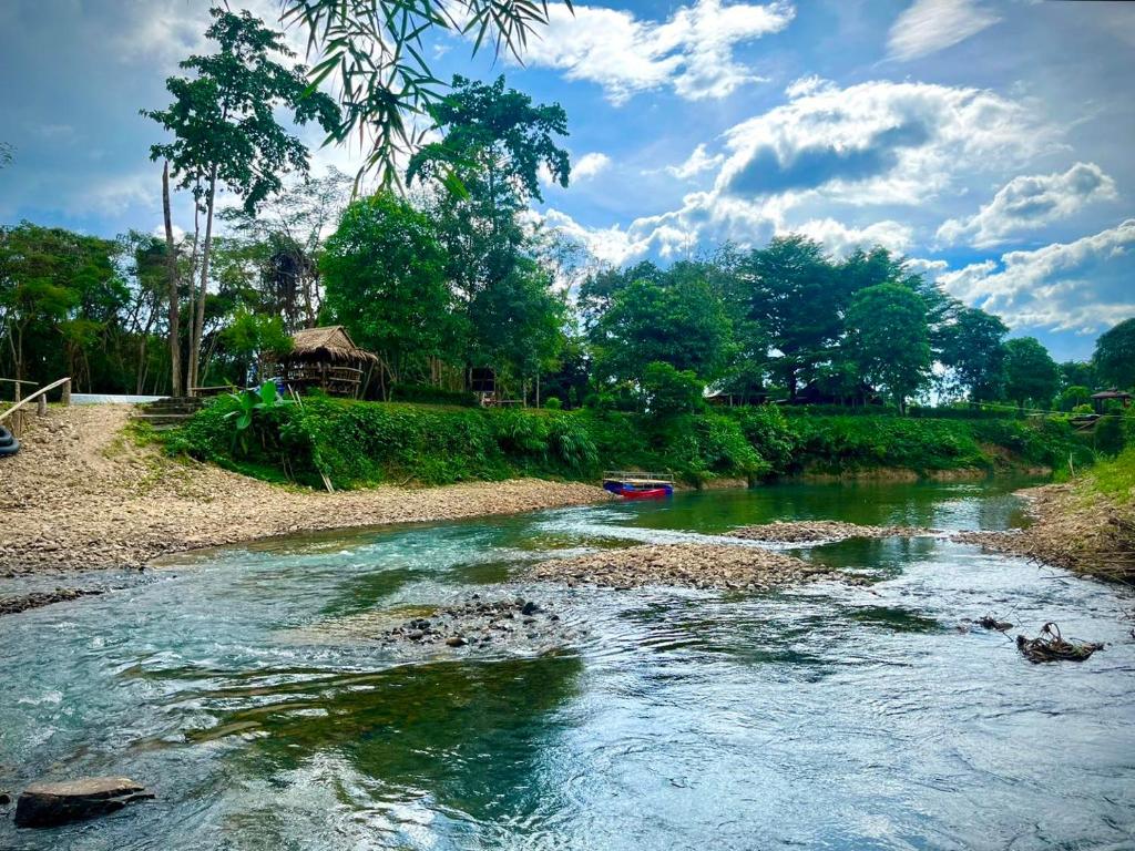 Ban Cha-om的住宿－Amano green resort，一条河,河中间有一条船