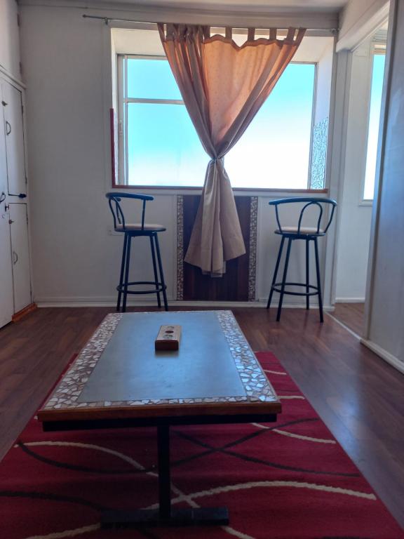 a room with a table and two chairs and a window at Apartamento por dia in Viña del Mar