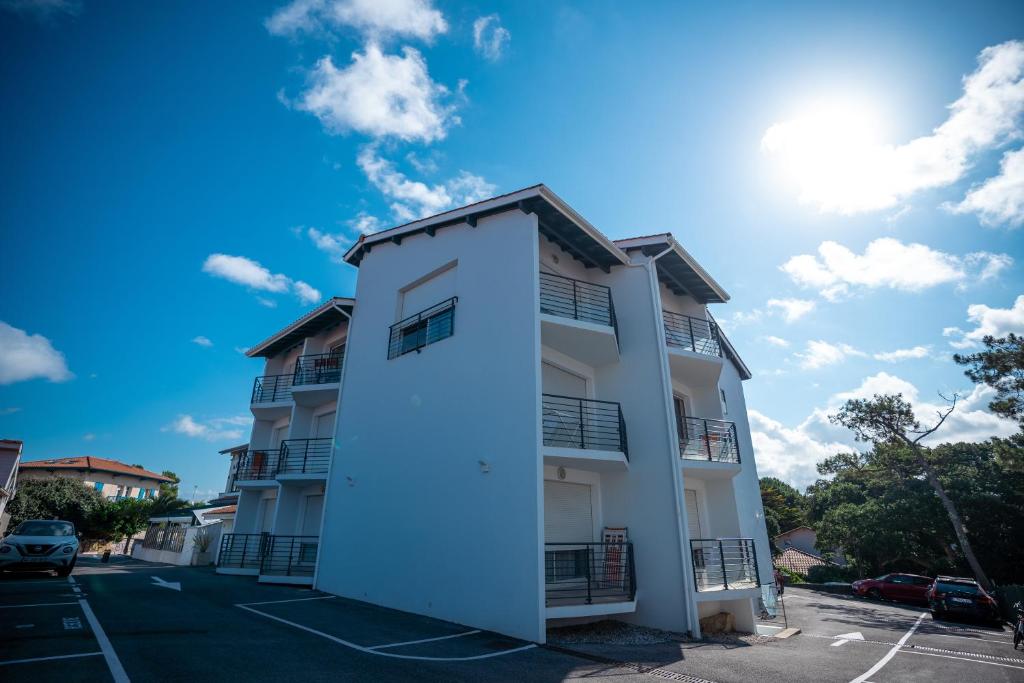 a white building in front of a parking lot at Plage Centrale in Soorts-Hossegor