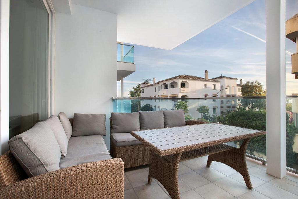 Un patio con un sofá y una mesa en un balcón. en Edificio Italia, en Benalmádena